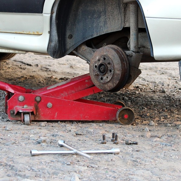 Car fixed in the garage, Hydraulic floor jack lift a , Wheel without tire, Key cross road and...