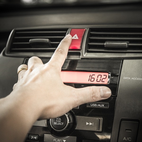 Closeup of young man pressing emergency button on car sport dash