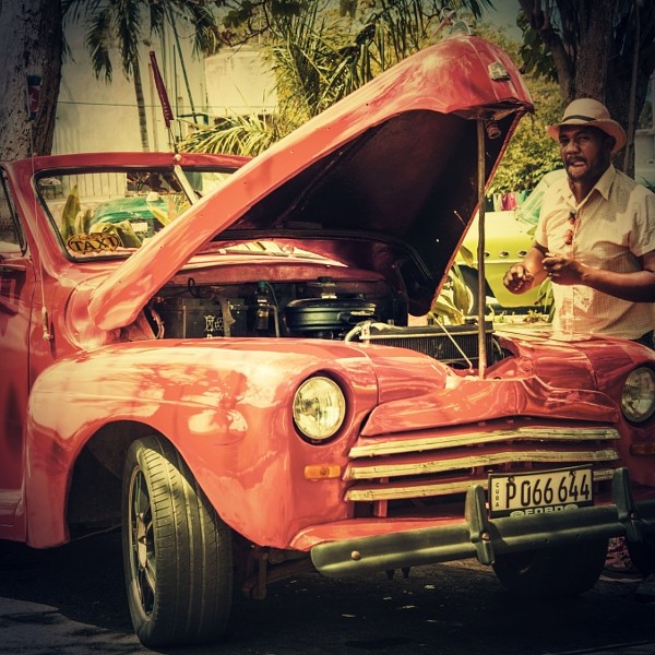 Cuban repairing his old american car