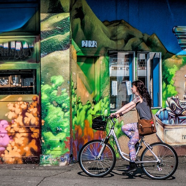 Girl riding on her bike, Commercial Drive, Vancouver BC